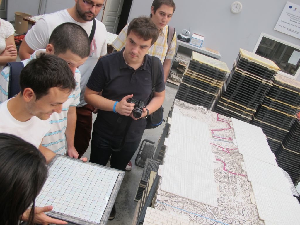 Cristi, care lucreaza in Fabrica de Mozaic, ne-a explicat noua jurnalistilor cum se aplica plasa de sustinere pentru piesele mozaicului